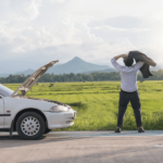 Young business man having trouble with his broken car waiting for emergency roadside service in Gresham