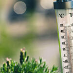 A thermometer is showing high temperatures above 100°F.