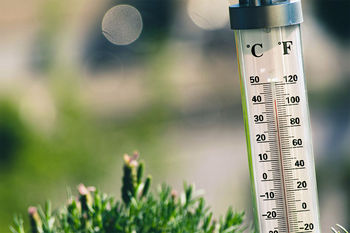 A thermometer is showing high temperatures above 100°F.